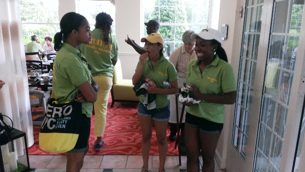OAIA family reunion – members in green shirts chatting indoors